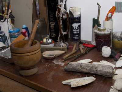 Si trova anche un tavolino colmo di pennelli, colori, pezzi di legno, sassi e altri oggetti utili per dar sfogo alla sua vena creativa
